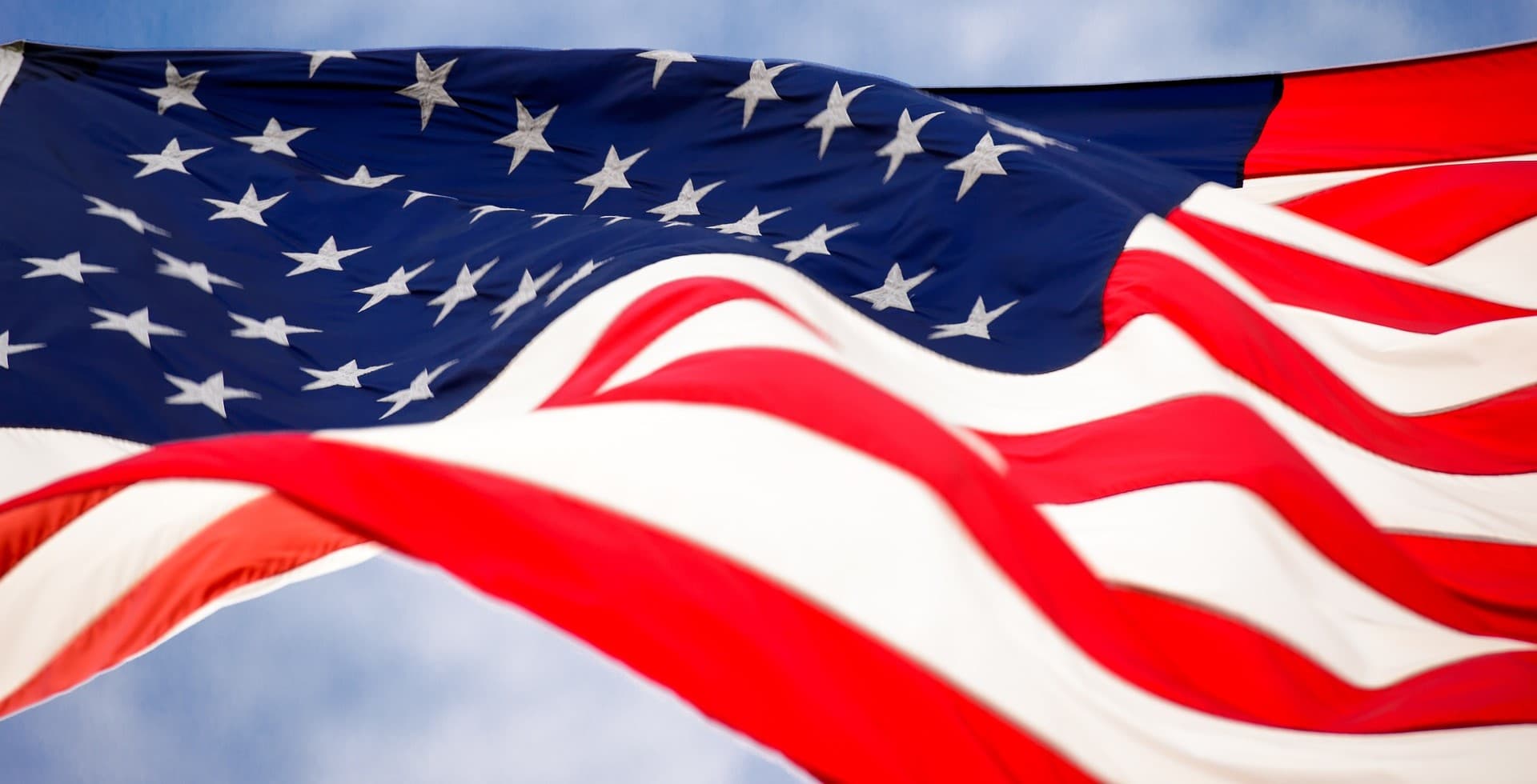 American Flag waving in the wind with background of sky